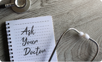 A stethoscope next to an open notebook with 'Ask Your Doctor' written on it, placed on a wooden surface.